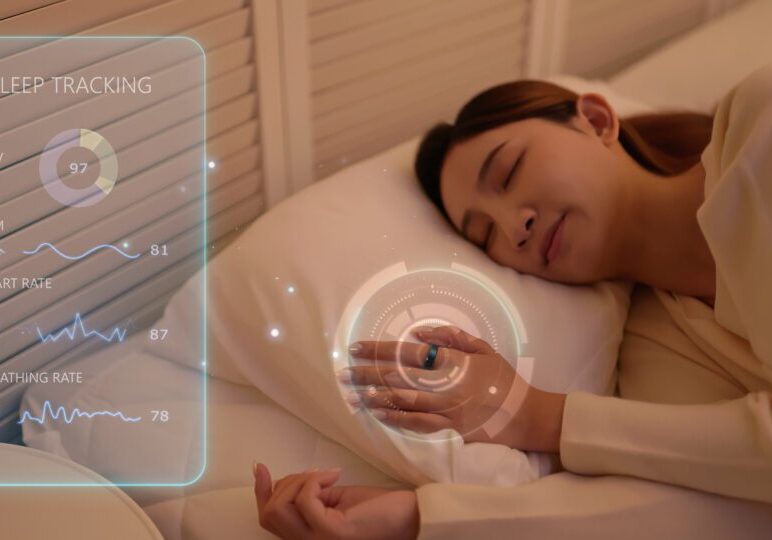 Close up young asian woman sleeping peacefully in her bedroom wearing  smart ring that monitors sleep quality and nighttime health data -  displays sleep tracking information with modern digital wellness technology